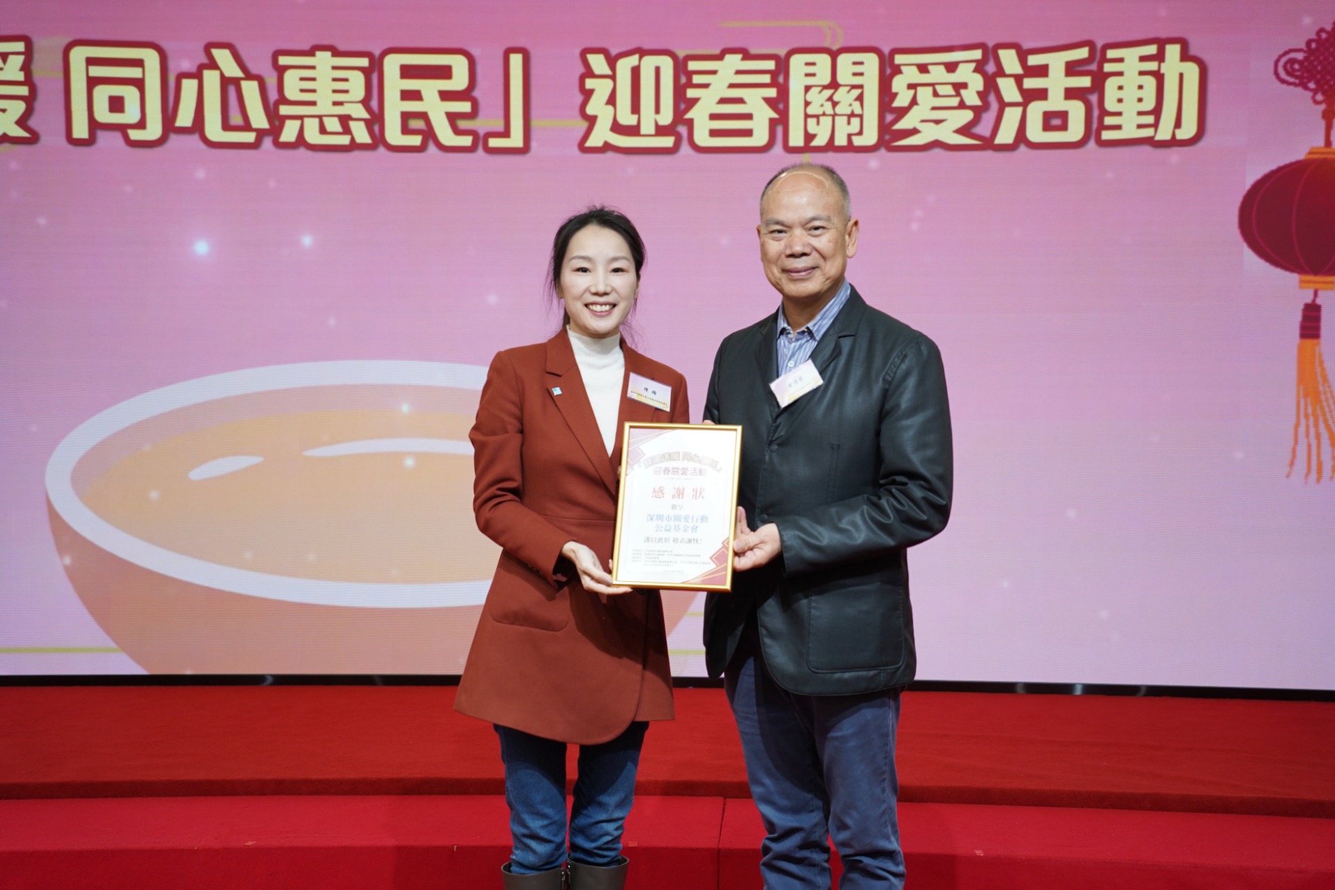 △香港深圳社團總會會長曾燈發向深圳市關愛行動公益基金會頒贈感謝狀，由陳梅代表接受。